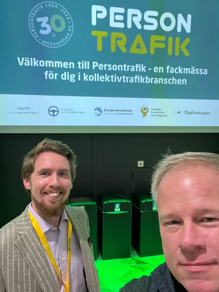 Två medarbetare från Mobilix framför välkomstskylten på fackmässan Persontrafik.