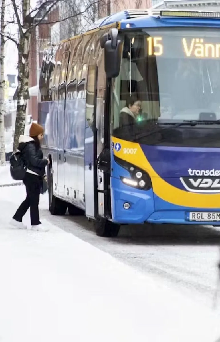 En resenär stiger på en buss mot Vännäs en vintermorgon.
